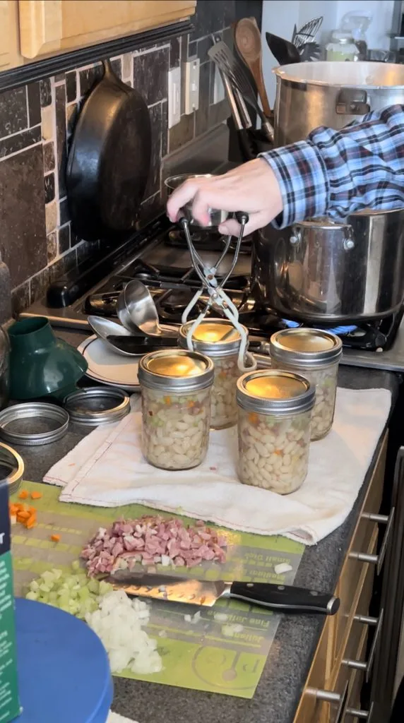 Picking up the pressure canned soup beans and ham jars for the canner