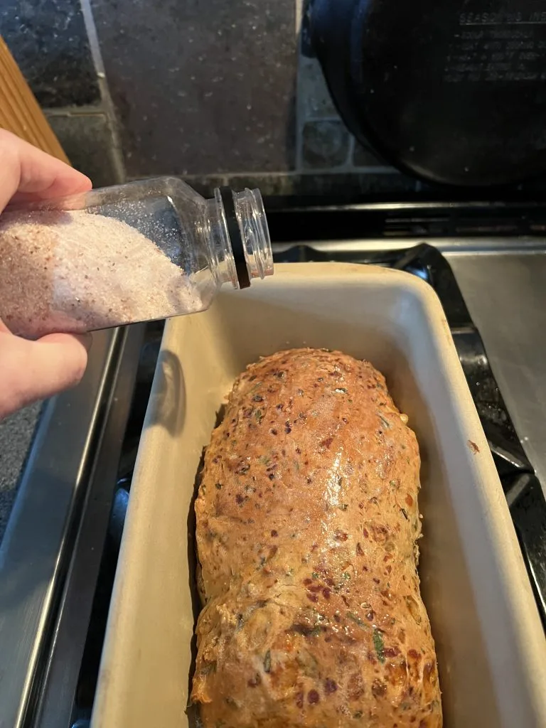 baked dilly onion bread recipe being buttered being salted