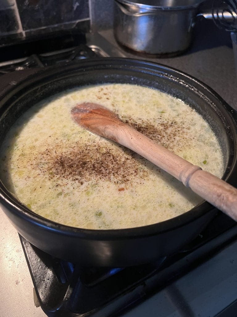 adding pepper to recipe for potato soup